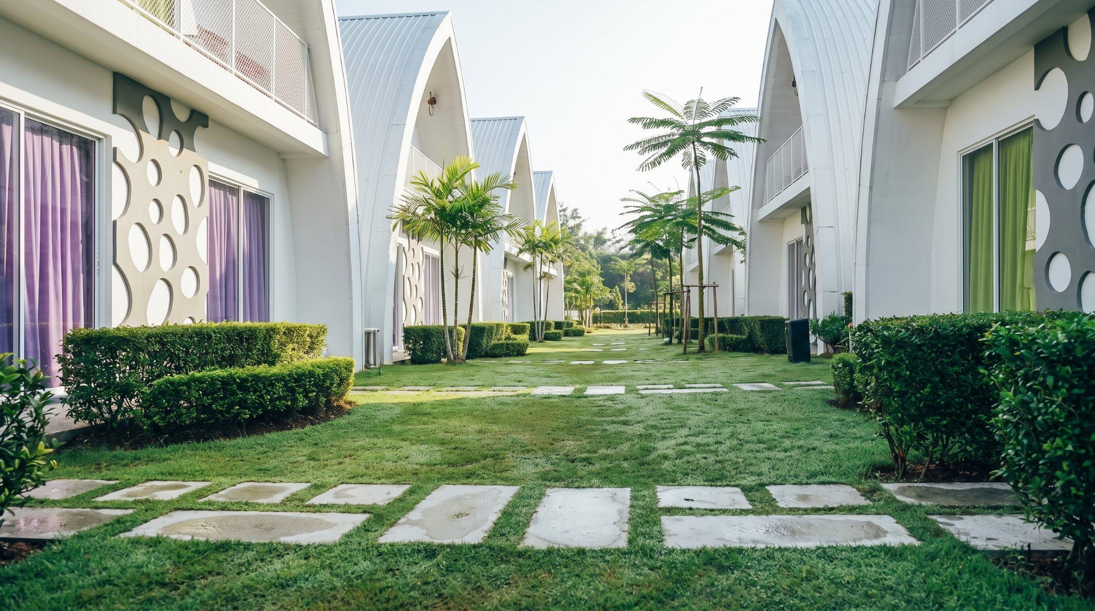 A lawn walkway between the white arched pods at the Salus retreat in Cyberjaya